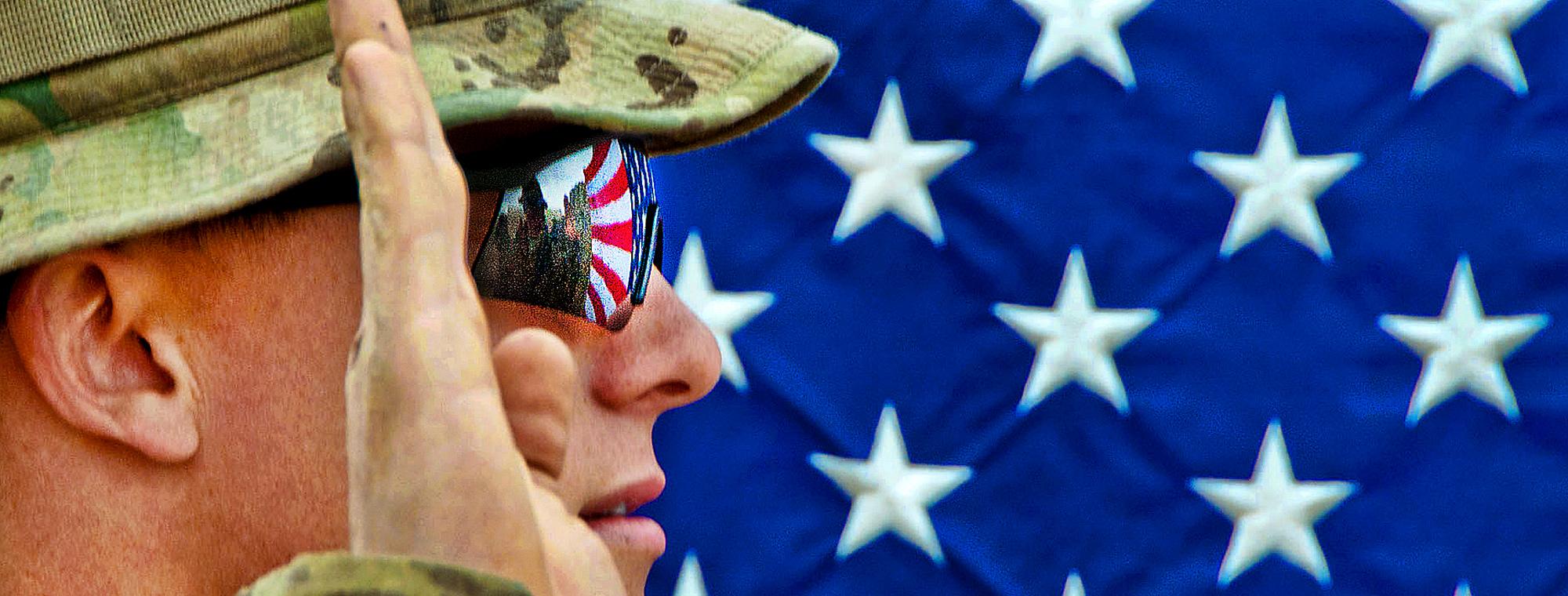 The American flag reflects in the glasses of an U.S. Army officer as he reenlists as a paratrooper on Combat Outpost Qara Baugh in Afghanistan's Ghazni province, April 22, 2012. The soldier is assigned to the 82nd Airborne Division’s 1st Brigade Combat Te